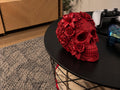 Red 3D printed floral skull sculpture covered in roses and lilies