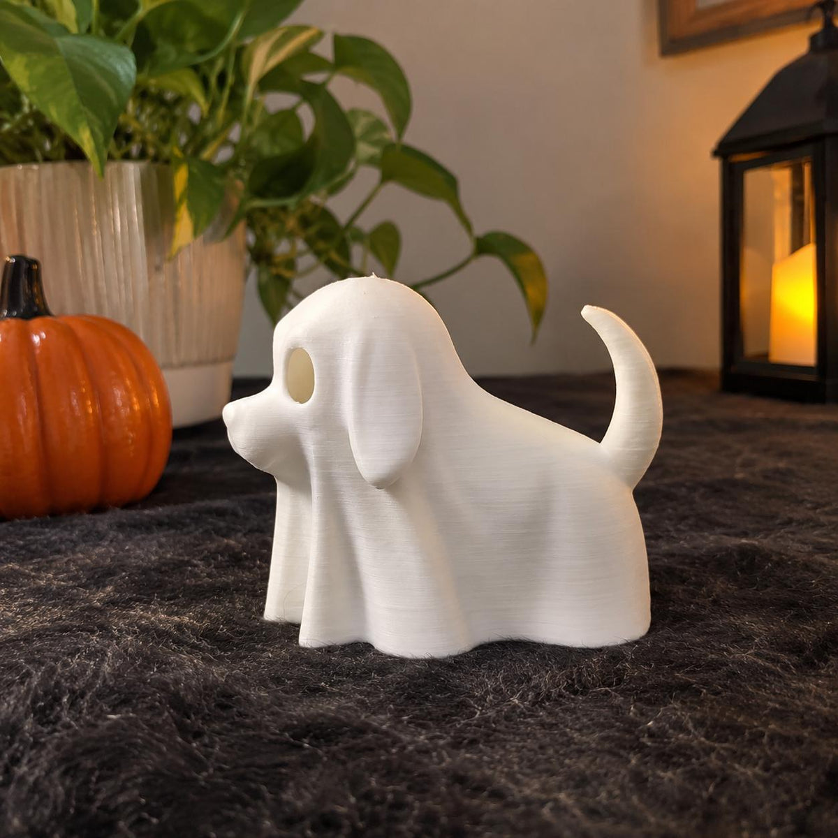White 3D printed ghost dog Halloween figurine next to a small pumpkin